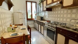 Une cuisine équipée d’une table à manger, de chaises, d’un réfrigérateur, d’une cuisinière et de placards.