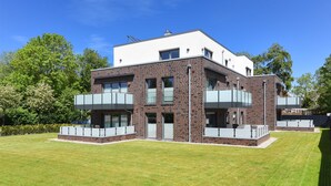 Een modern gebouw met twee verdiepingen, een plat dak en grote ramen.