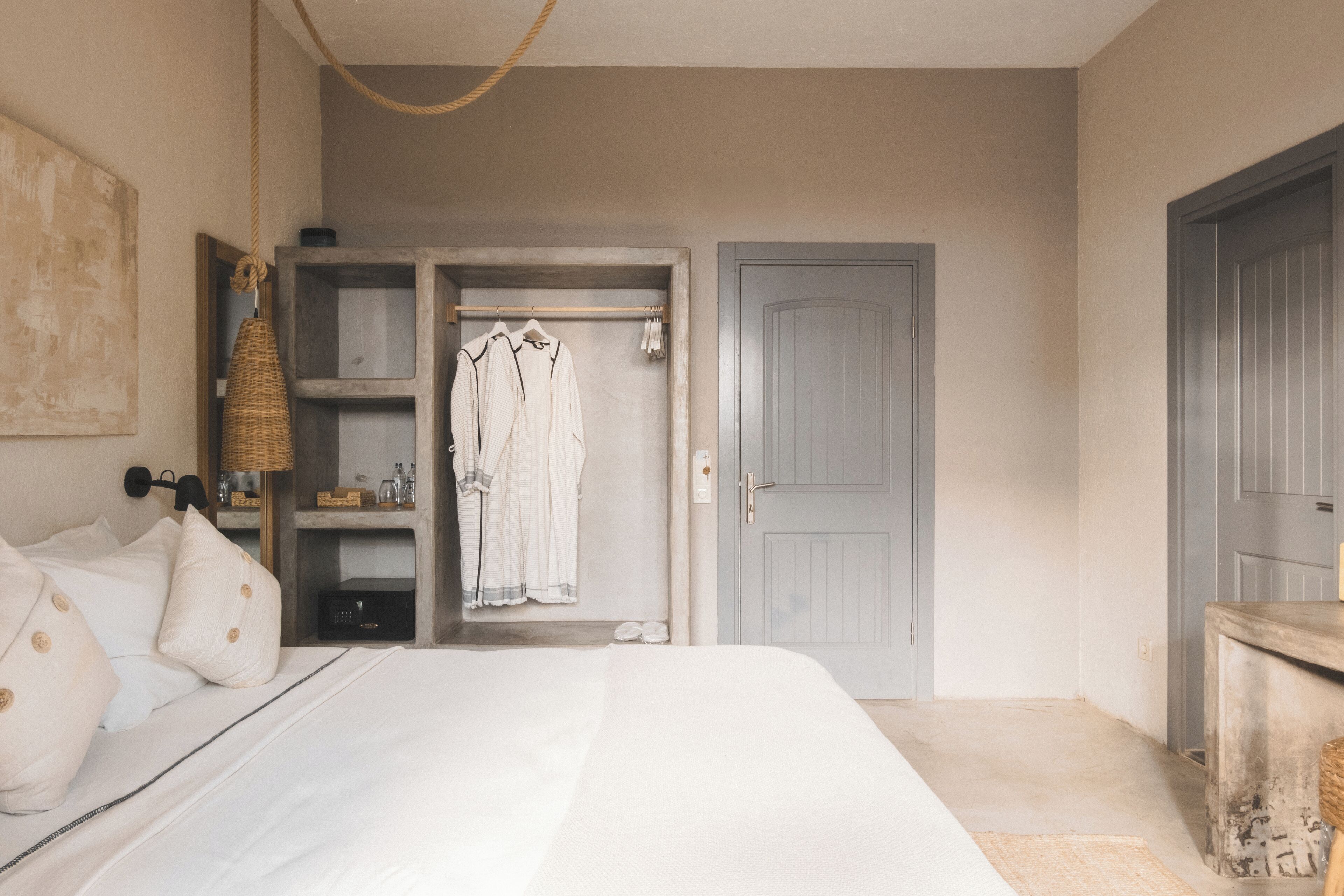 A bedroom with a bed, a wardrobe, and a door.