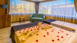 Una habitación de hotel con una cama grande, un sofá, un escritorio y un televisor.
