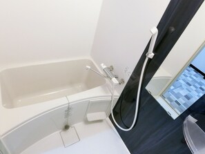 Een aparte badkuip en douche, gratis toiletartikelen, een haardroger