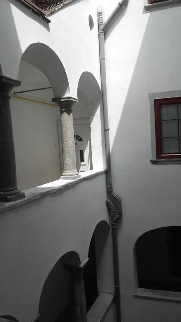 A narrow corridor with arches and a window, suggesting a historical or traditional architectural style. - Codelli Deluxe Unique Fresko Apartments (Ljubljana)