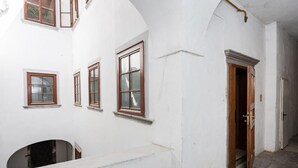 A narrow corridor with white walls and wooden-framed windows. - Codelli Deluxe Unique Fresko Apartments (Ljubljana)