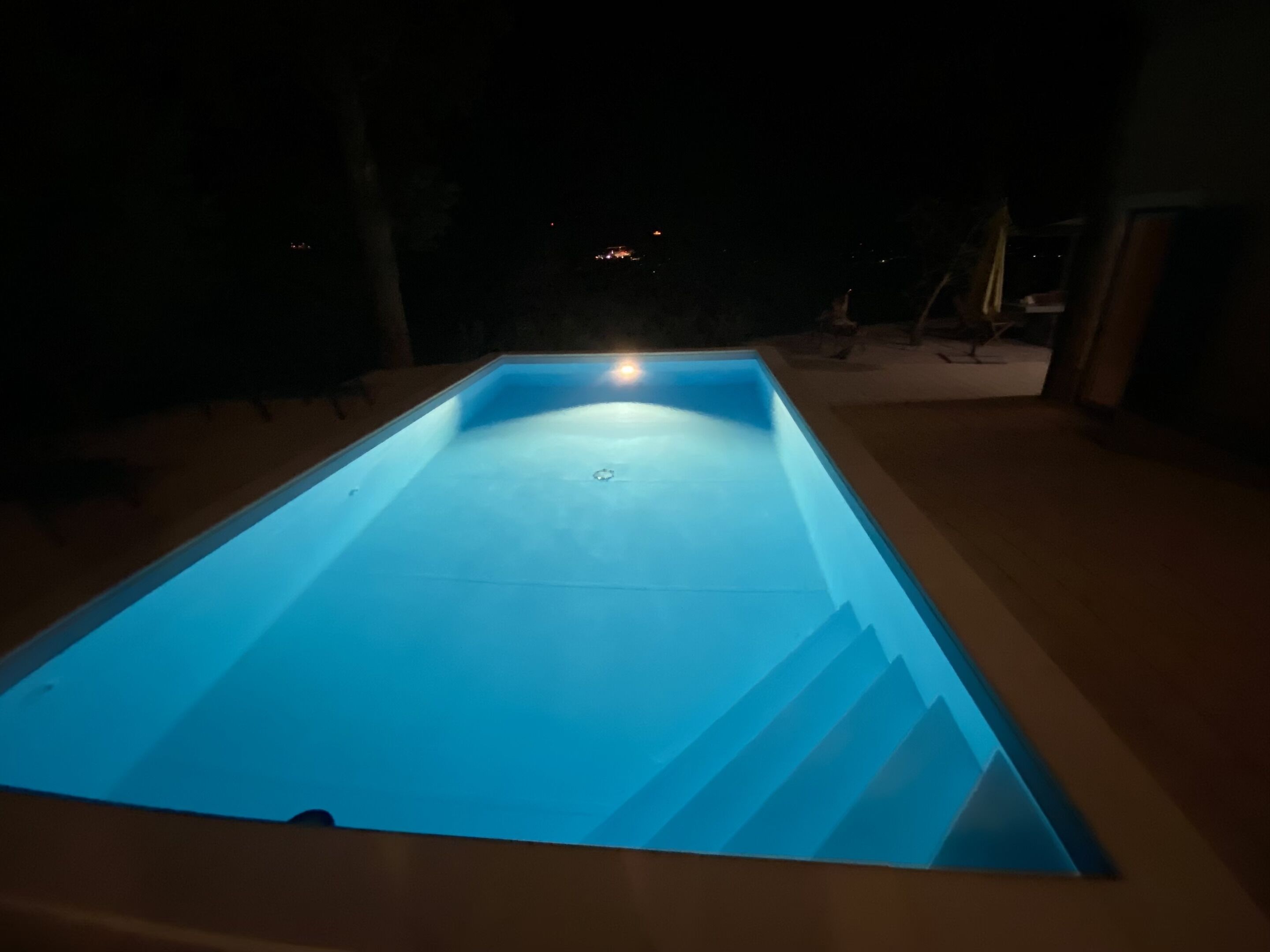 A rectangular swimming pool with a smooth surface and a central drain.