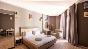 A hotel room with a large bed, a desk, a chair, and a mirror. - Orbi Plaza Hotel Official (Batumi)