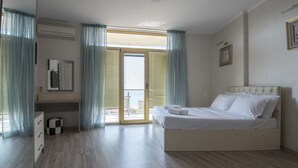 A bedroom with a bed, a dresser, a mirror, and a window with curtains. - Orbi Plaza Hotel Official (Batumi)