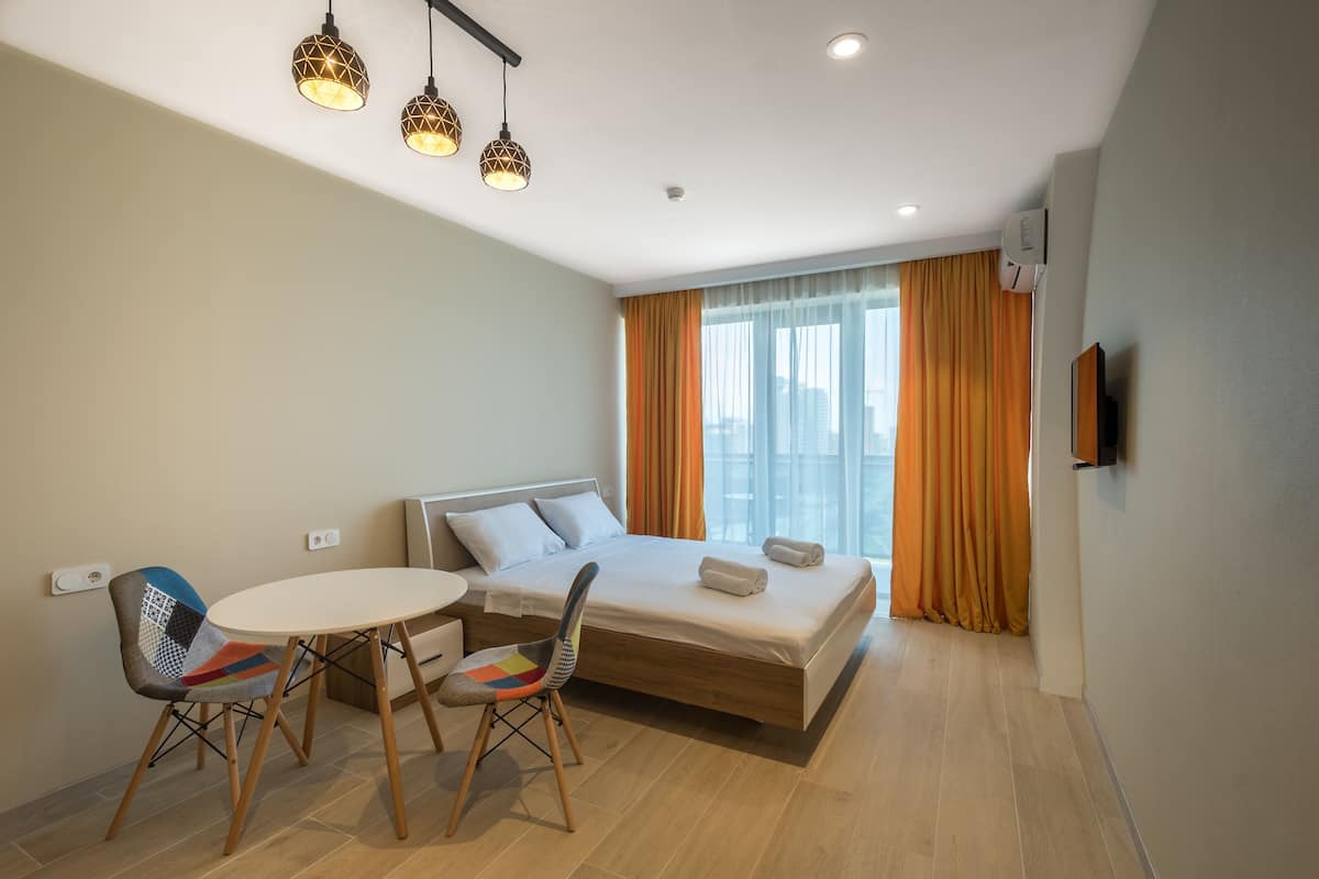 Une chambre d’hôtel moderne équipée d’un lit, d’une table à manger, de deux chaises et d’un téléviseur.