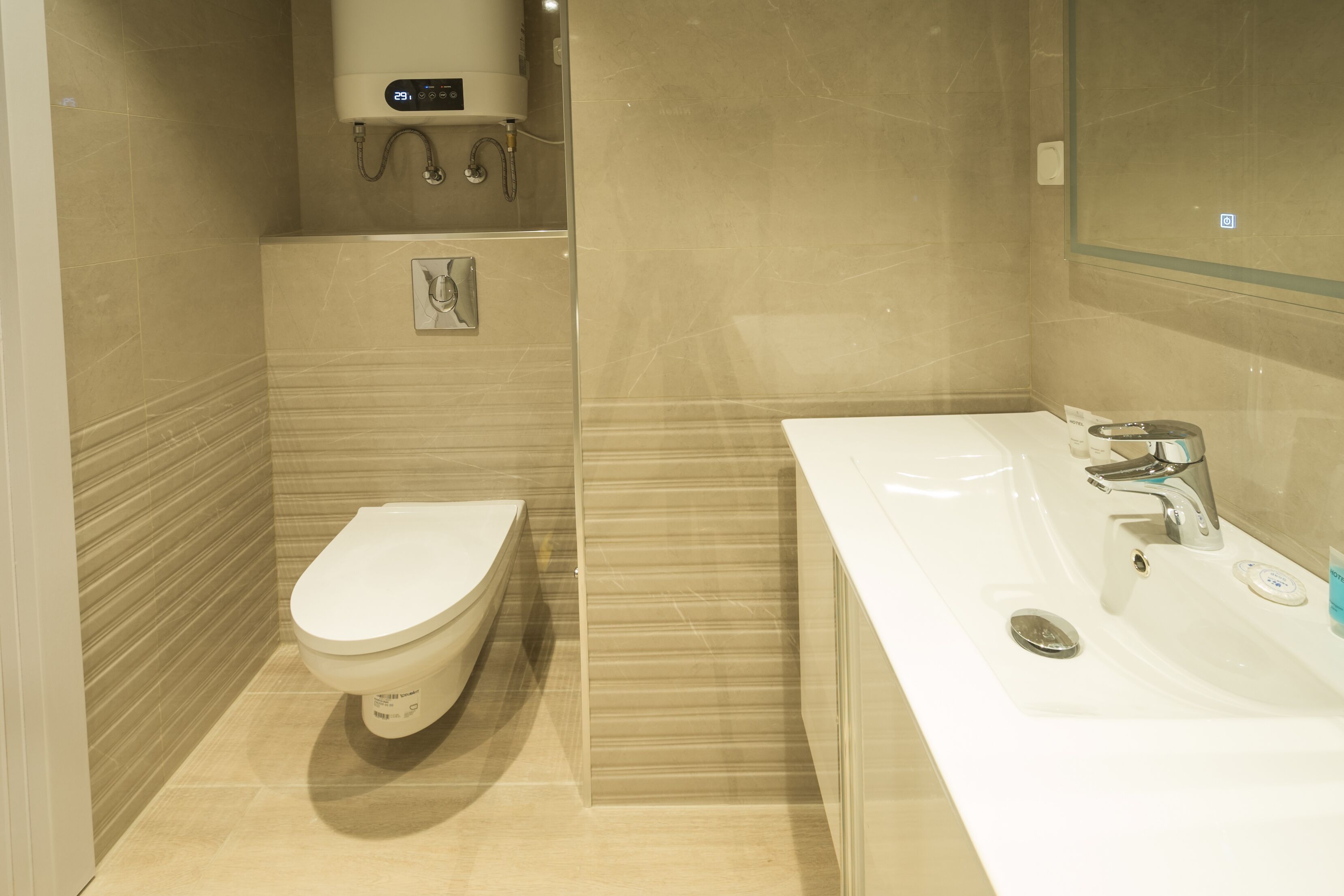 Een moderne badkamer met toilet, wastafel en douche.