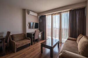 Una sala de estar moderna con un sofá, una mesa de centro y un televisor sobre un mueble.