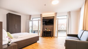 Un dormitorio moderno con una cama, un escritorio y un sofá.