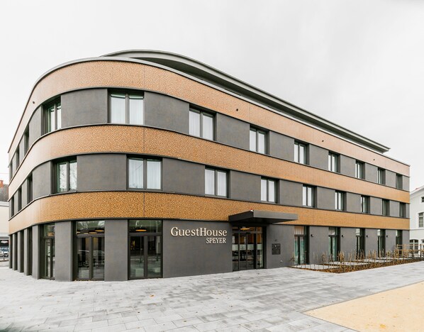 A modern building with a curved facade, large windows, and a sign reading "GuestHouse SPEYER". - GuestHouse Speyer (Speyer)