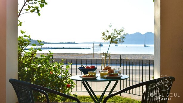 A table with breakfast items and a view of the sea.