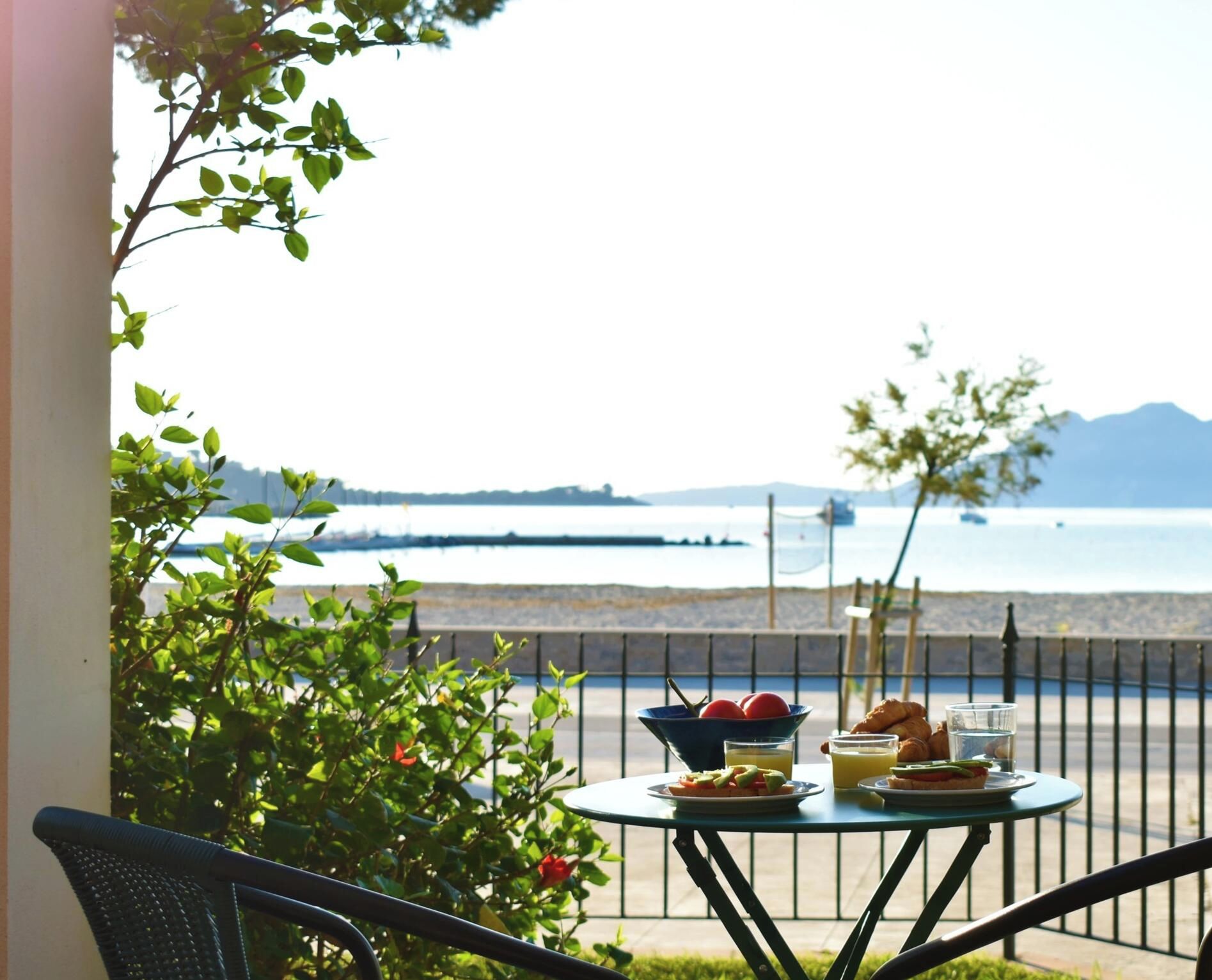 Mesa com itens de café da manhã e vista para o mar.