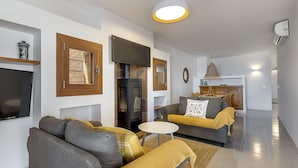 A modern living room with a sofa, a small round table, and a fireplace.