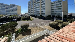 A multi-story residential building with a parking lot and a small garden area. - Cozy 1st-Floor Apartment, 200m from Beach, Balcony, Parking & WiFi Options - Saint-Hilaire-de-Riez (Saint-Hilaire-de-Riez)