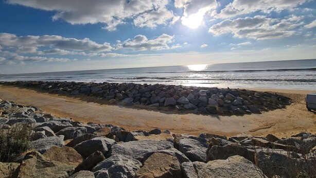A rocky beach with a clear sky and the sun setting over the ocean. - Cozy 1st-Floor Apartment, 200m from Beach, Balcony, Parking & WiFi Options - Saint-Hilaire-de-Riez (Saint-Hilaire-de-Riez)