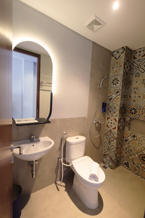A bathroom with a sink, toilet, and shower.