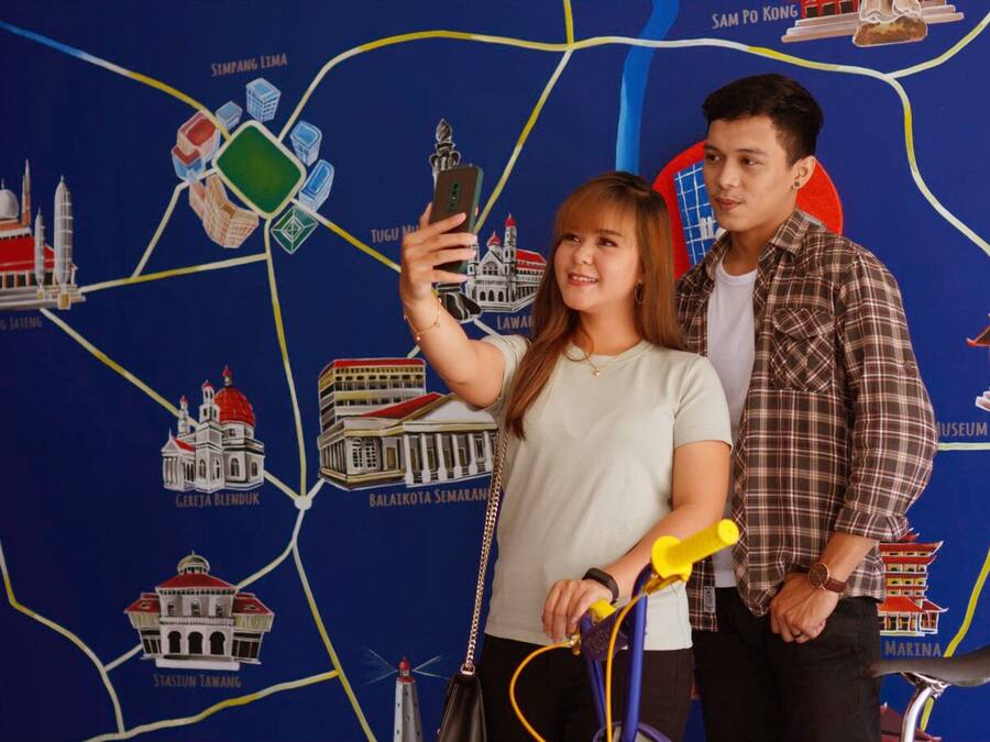 Um mapa com vários pontos turísticos e uma pessoa tirando uma selfie.