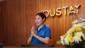 A person standing in front of a wooden wall with the word "HOUSTAY" visible. - Hotel Youstay Semarang By Sinergi (Semarang)