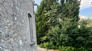 A rustic stone building with a narrow staircase leading to a wooden deck. - Casa Felice Due - Contrada Guido (con piscina) (sellia marina)