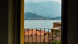 Vista de un lago con montañas al fondo y edificios en primer plano.