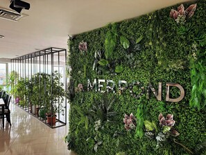 Un mur agrémenté d’un jardin vertical et du mot « MERPOND » écrit en lettres métalliques.
