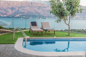 Una piscina al aire libre, tumbonas