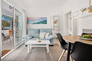 Ein modernes Wohnzimmer mit Sofa, Couchtisch und Essbereich.