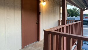 A building entrance with a wooden door, a metal handle, and a small light fixture above it. - 1326-#9 Comfy studio in downtown  (San Antonio)