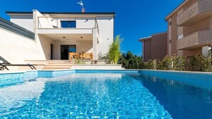 A modern building with a swimming pool in front.