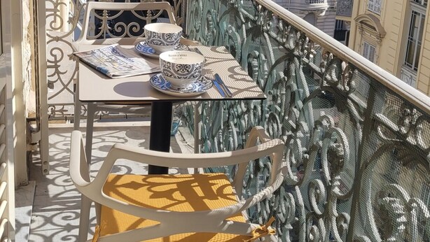 A balcony with a table set for two, featuring a patterned tablecloth and matching cups. - Charming flat Carré d'Or/Musiciens, 5 min away from the beach, WIFI (Nice)