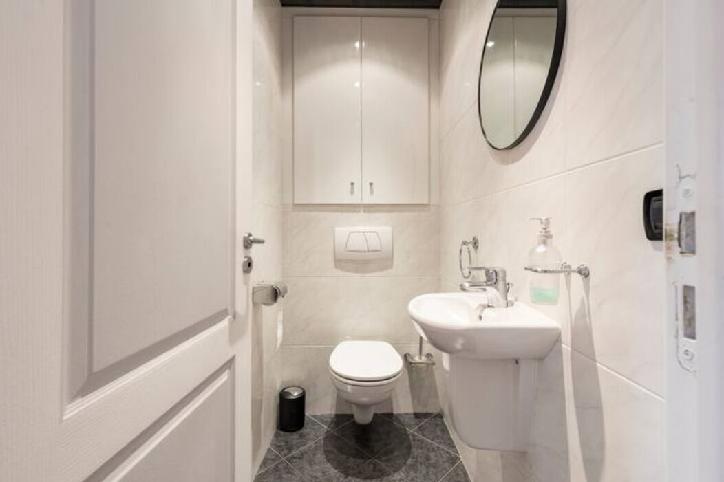 Un bagno compatto con il water, un lavandino e uno specchio.