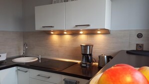 Eine moderne Küche mit Spüle, Kaffeemaschine und Wasserkocher auf der Arbeitsfläche.