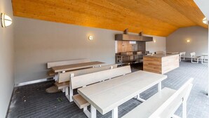 An open-plan kitchen and dining area with wooden benches and a central island.