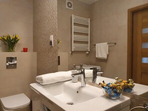 A modern bathroom with a white sink, chrome faucets, a towel rack, and a mirror. - Apartament Polanki Park - 365PAM (Kolobrzeg)