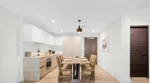 Enjoy meals in this stylish dining area with a central table for four, surrounded by comfortable chairs.