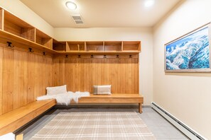 Enjoy a serene space with a large painting of a mountainous landscape, a wooden bench, and ample storage.