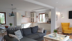 A modern living room with a grey sofa, a coffee table, and a yellow armchair. - Apartamenty Morskie Historie - 365PAM (Kolobrzeg)
