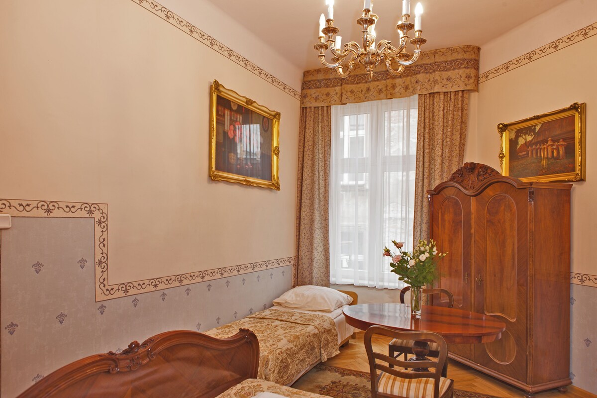 Un dormitorio con cama, armario de madera, mesa y candelabro.