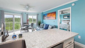 A modern kitchen with a marble countertop, a sink, and a dining area with a table and chairs. - Snorkel & Dive Legendary Coral Reefs - Then Relax Poolside with a Drink! (Tavernier)