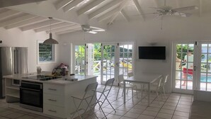A spacious kitchen with a large island, white cabinetry, and a ceiling fan. - Jolly Harbour, 3 bedroom villa, pool, close to beach and all amenities. (Jolly Harbour)