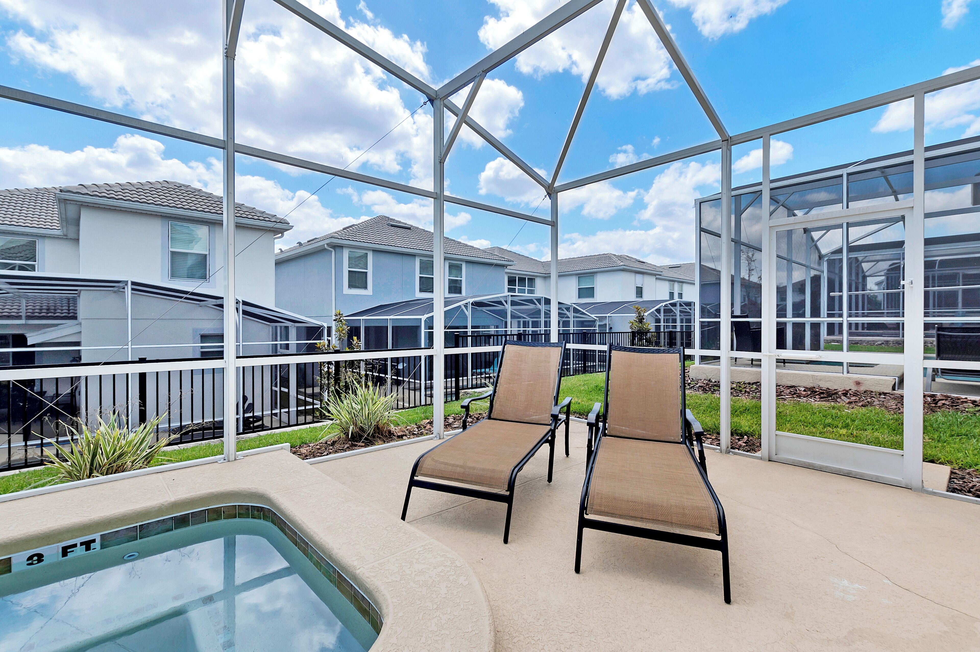 Un espacio al aire libre techado con piscina, sillas de descanso y vistas a edificios residenciales.