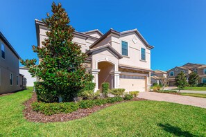 A two-story house with a front entrance, a driveway, and a well-maintained lawn. - 1450 Rolling Fairway Drive (Davenport)
