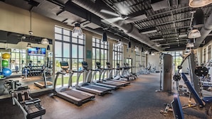 Ein Fitnessstudio mit Laufbändern, Kraftgeräten und Trainingsbällen.