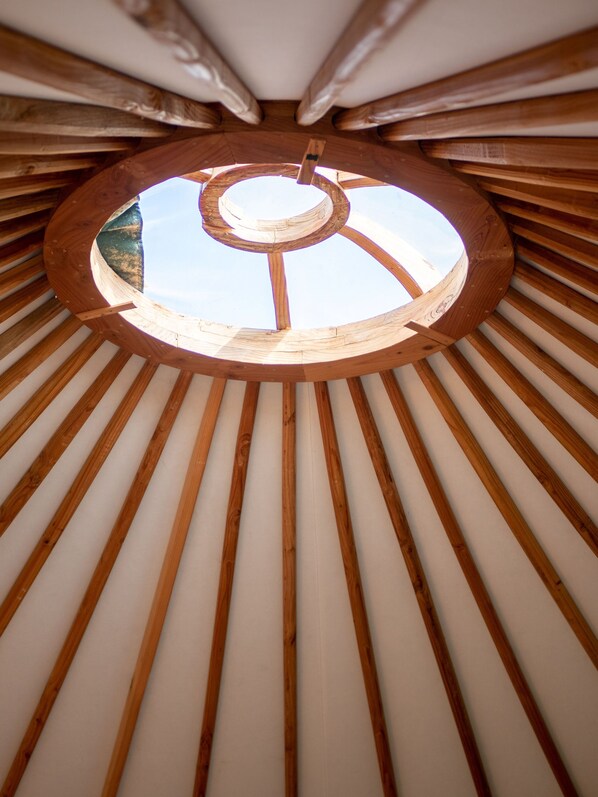 Un tragaluz circular con vigas de madera que irradian desde el centro.
