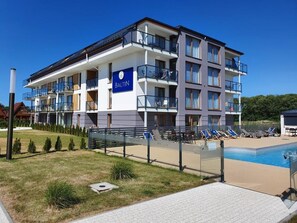 Ein mehrstöckiges Hotel mit Schwimmbad, Außenbereich und einem Schild mit der Aufschrift "BALTIN".