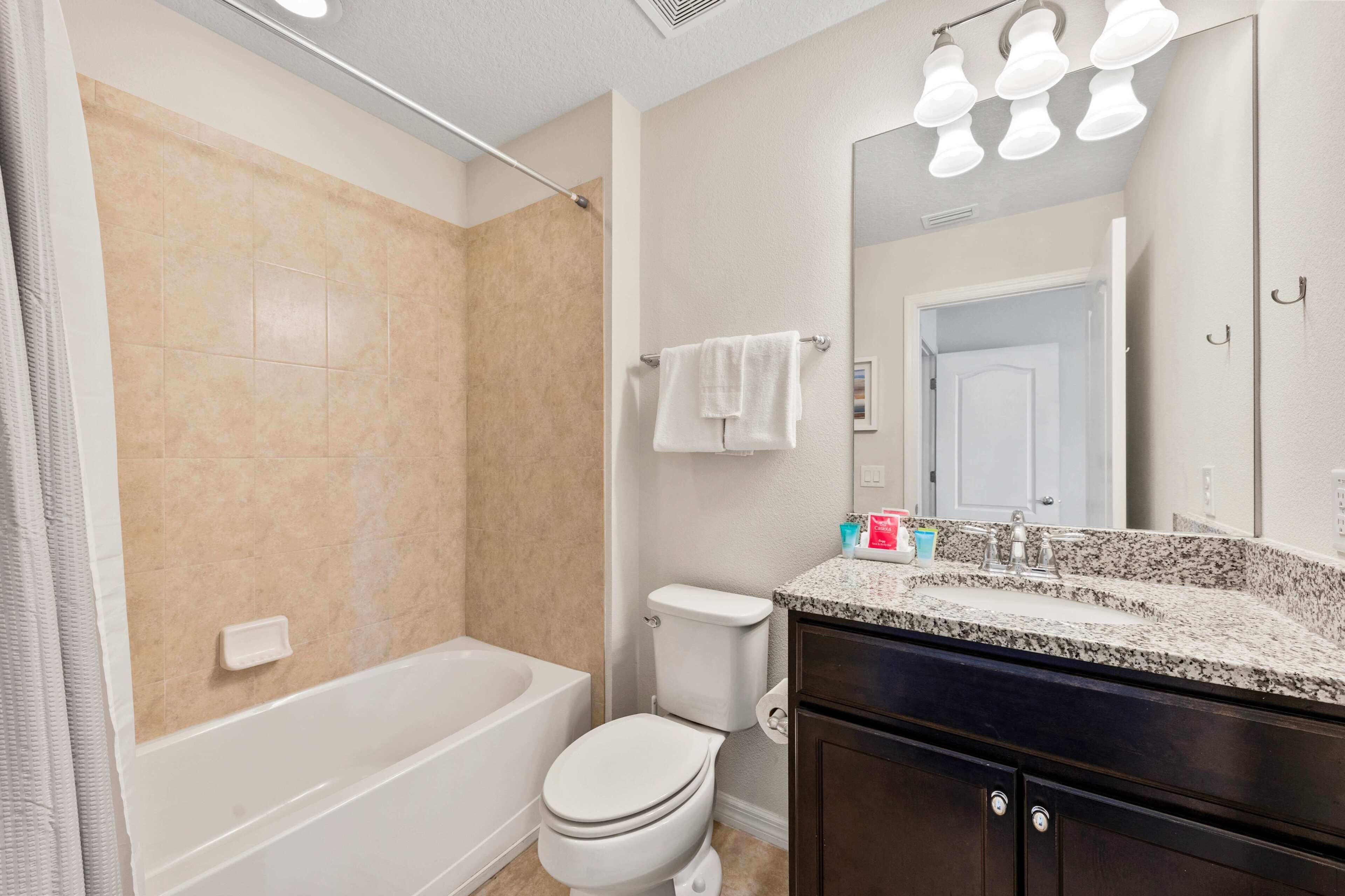 Un bagno con una vasca, un water e un mobile lavabo con specchio.