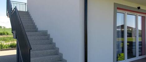 A staircase leading to a building with a glass door and a sign indicating a business or office space.