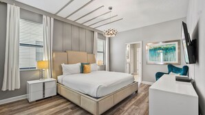 A modern bedroom with a large bed, bedside tables, a desk, and a TV. - Private Pool/spa & Gameroom, Near Wdw! Sleeps 25 (Kissimmee)