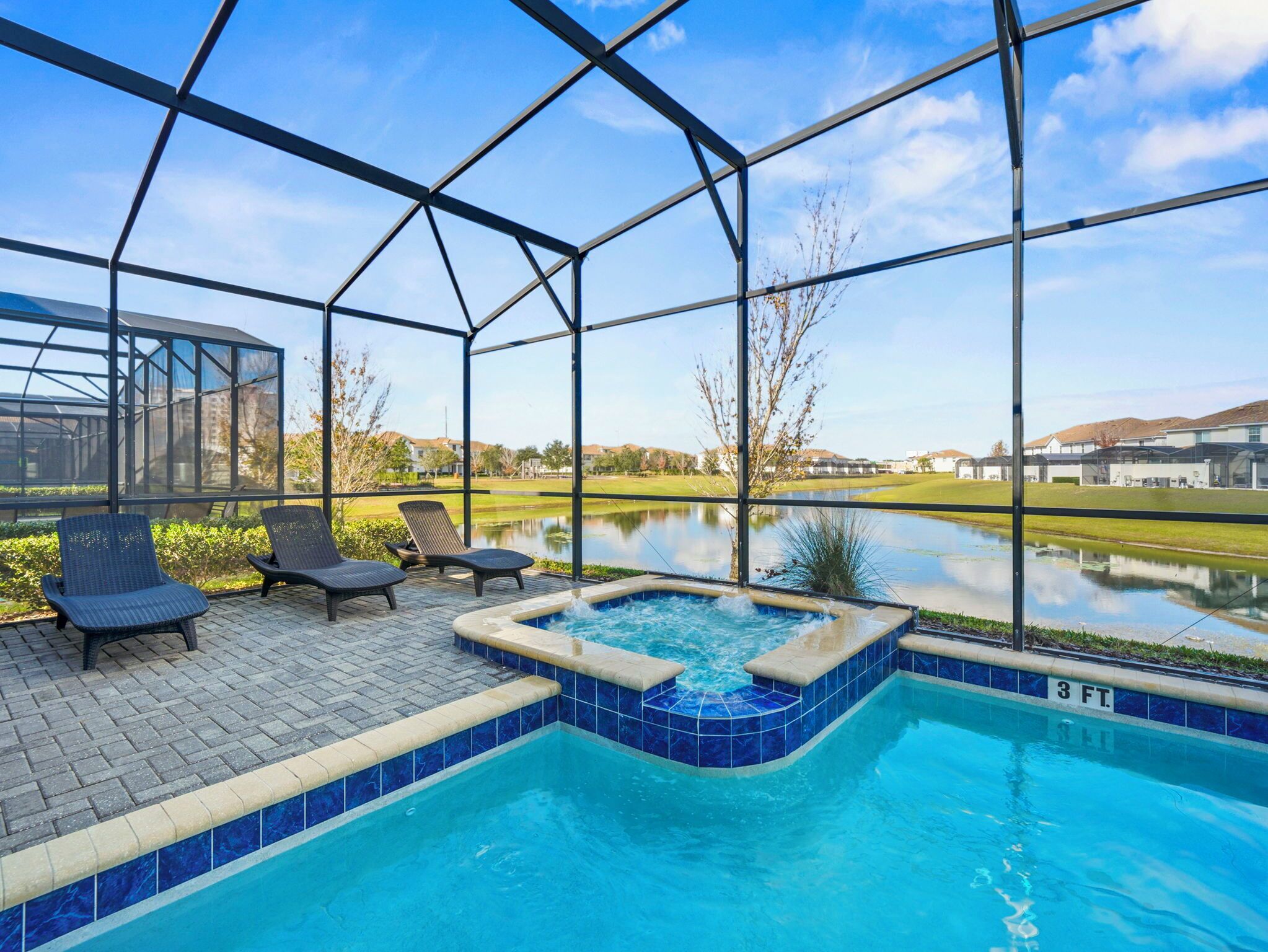 Une piscine extérieure couverte, dotée de chaises longues et d’un jacuzzi, le tout entouré d’une structure en verre.